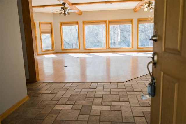 spare room with baseboards, brick floor, and a ceiling fan