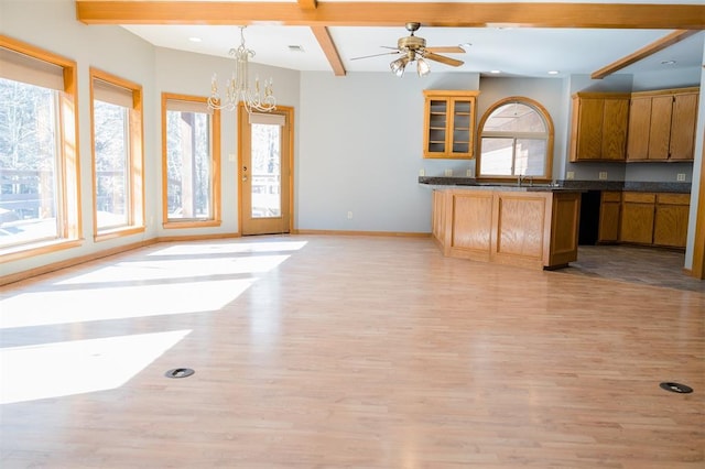 kitchen with a wealth of natural light, beam ceiling, and dark countertops