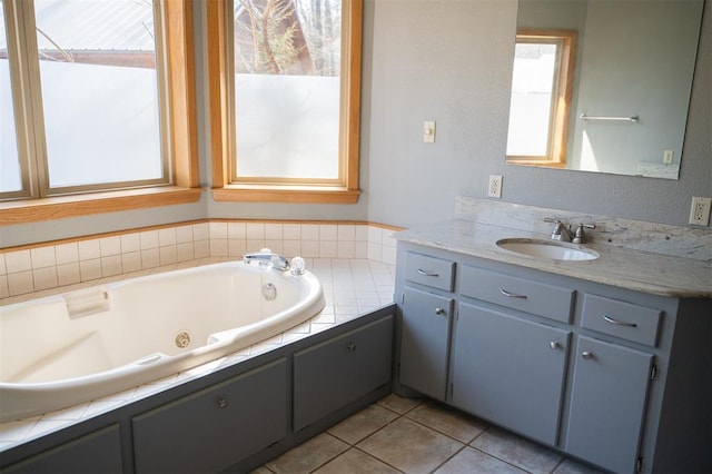 bathroom featuring tile patterned floors, a tub with jets, and vanity