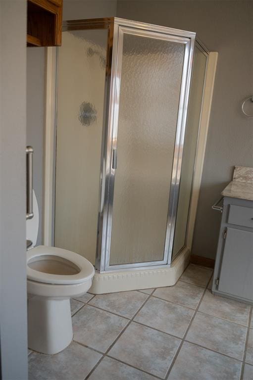 full bathroom with tile patterned floors, toilet, a stall shower, and vanity