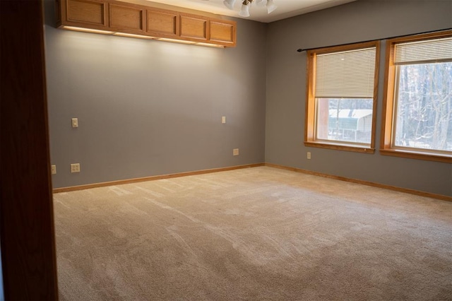 empty room with baseboards and light colored carpet