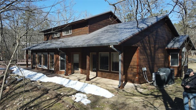 snow covered house featuring central AC unit