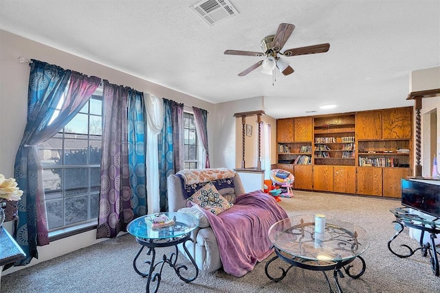 carpeted living room with ceiling fan and a textured ceiling