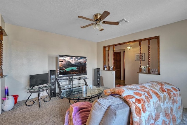 carpeted living room featuring ceiling fan and a textured ceiling