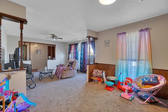 rec room with ceiling fan, carpet floors, and a textured ceiling