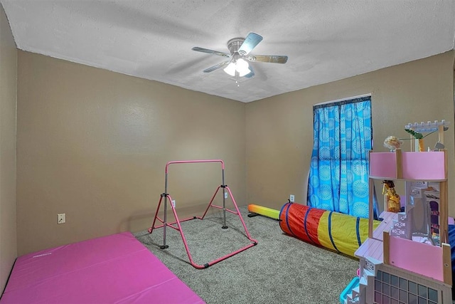 game room with ceiling fan, carpet, and a textured ceiling