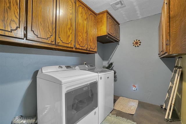 clothes washing area featuring cabinets, a textured ceiling, and independent washer and dryer