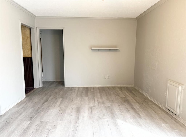 unfurnished room featuring baseboards, wood finished floors, and crown molding