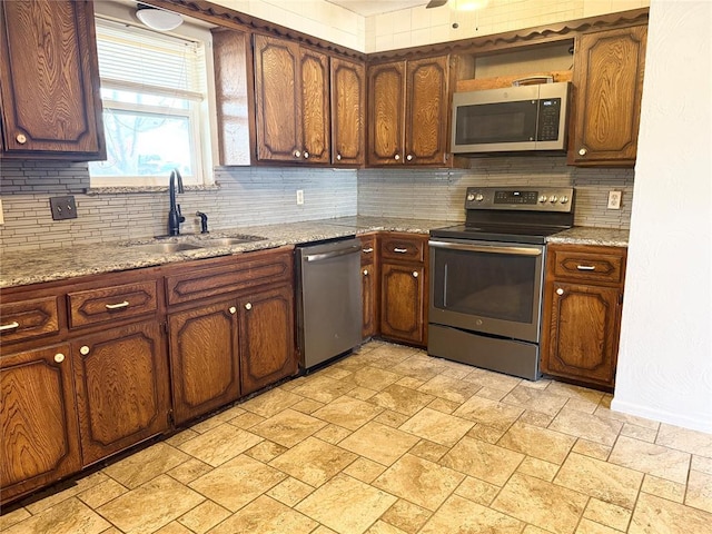 kitchen featuring a sink, stone finish flooring, open shelves, tasteful backsplash, and appliances with stainless steel finishes