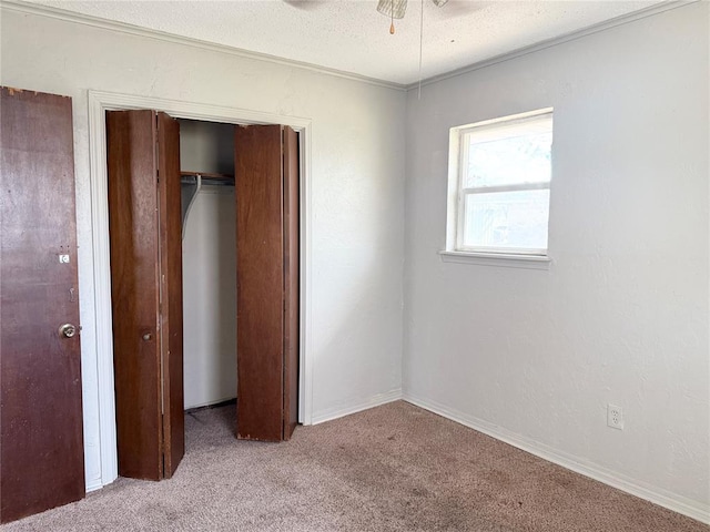 unfurnished bedroom with a closet, a textured ceiling, and carpet floors