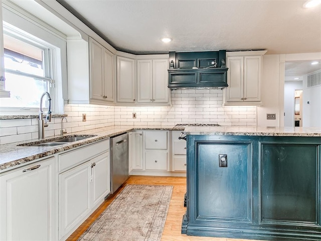 kitchen with sink, light hardwood / wood-style floors, light stone countertops, white cabinets, and stainless steel dishwasher