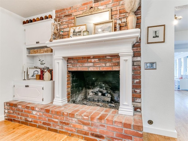 interior details with hardwood / wood-style floors and a brick fireplace