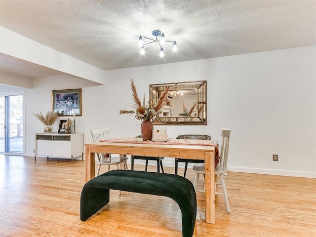 dining room featuring a textured ceiling and light wood-type flooring