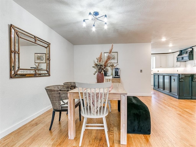 dining space with light hardwood / wood-style floors and a textured ceiling