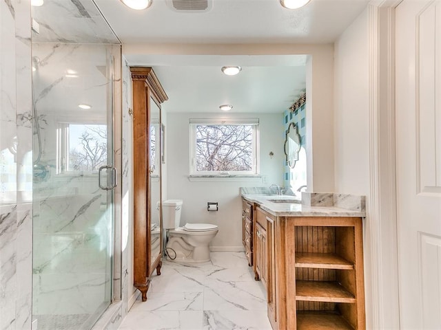 bathroom featuring toilet, vanity, and a shower with shower door