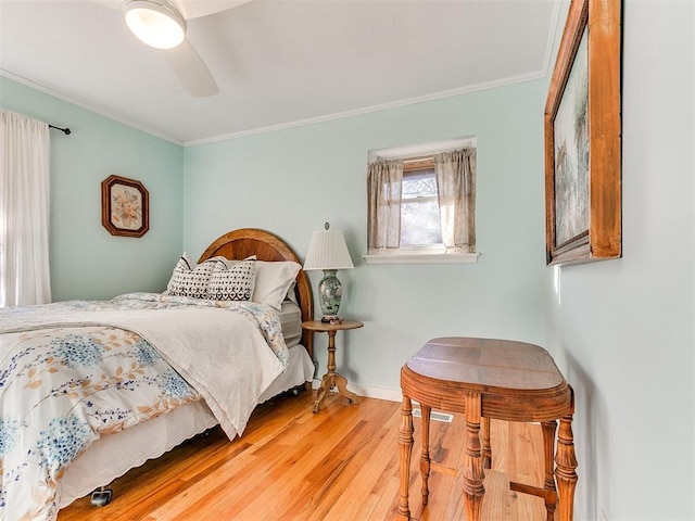 bedroom featuring wood-type flooring, ornamental molding, and ceiling fan