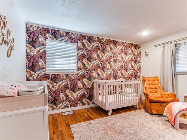 bedroom featuring hardwood / wood-style floors and a crib