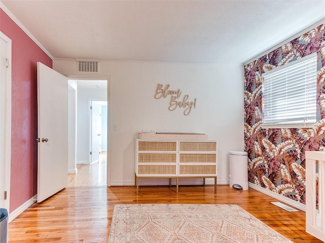 interior space with crown molding and light wood-type flooring