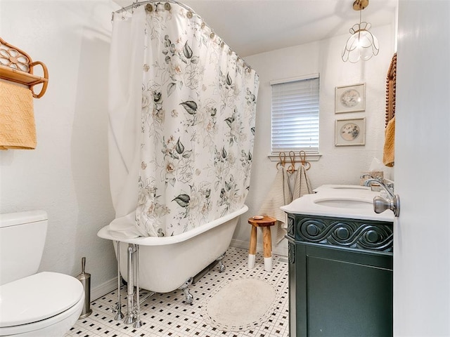 bathroom featuring tile patterned flooring, vanity, a tub, and toilet