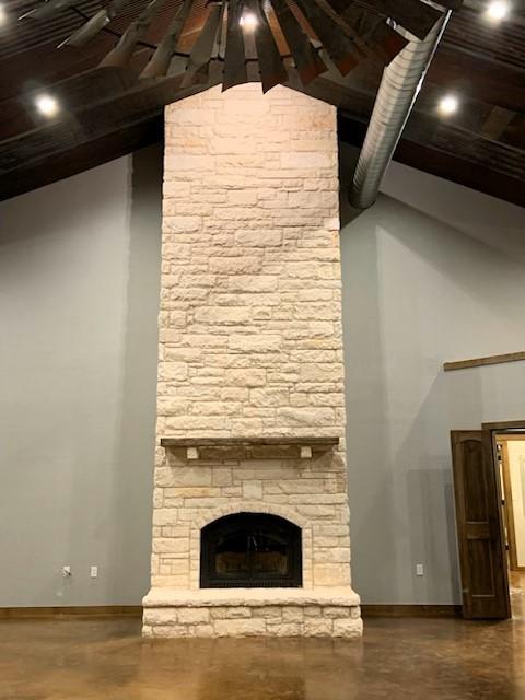 unfurnished living room featuring vaulted ceiling and a fireplace