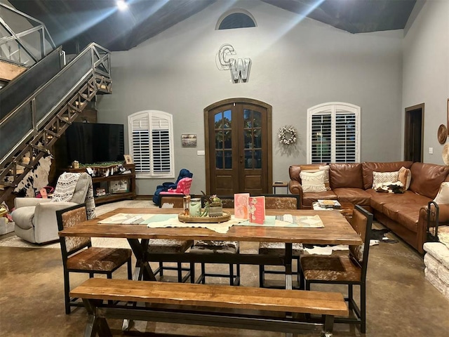 dining area featuring a high ceiling, concrete floors, and french doors