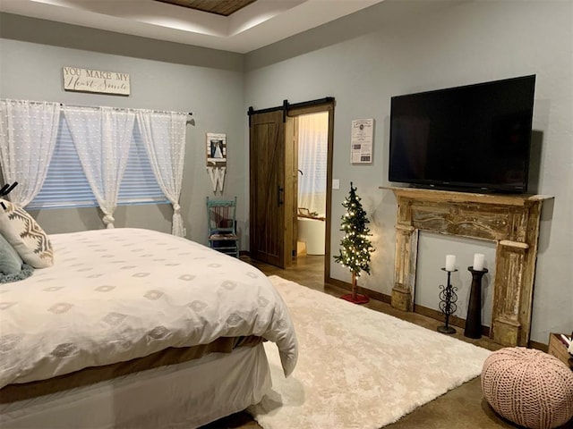 bedroom with carpet, a barn door, and ensuite bathroom