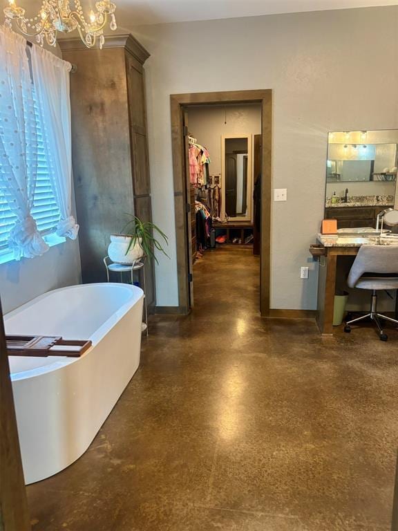 bathroom featuring a bath and a chandelier