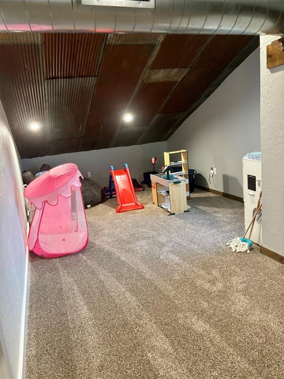 recreation room featuring lofted ceiling and carpet flooring