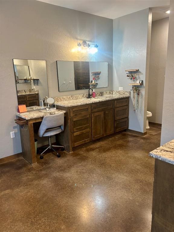 bathroom featuring vanity, concrete floors, and toilet