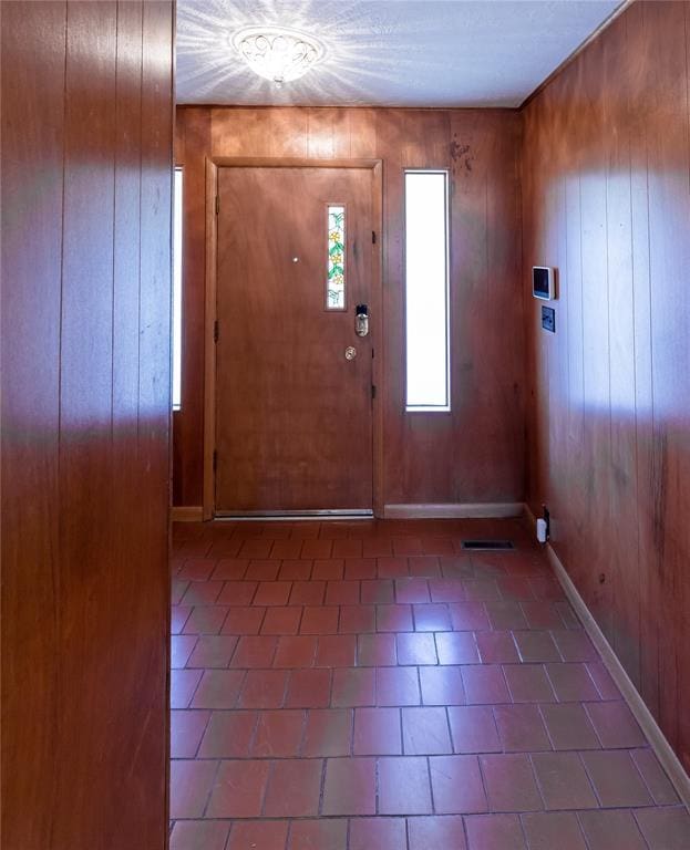 foyer entrance featuring wooden walls