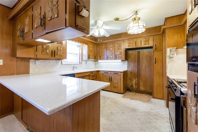 kitchen with pendant lighting, decorative backsplash, ceiling fan, kitchen peninsula, and gas stove