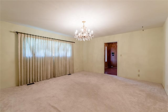 carpeted empty room with a chandelier