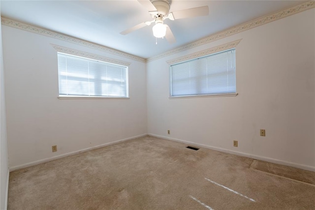 carpeted spare room featuring ceiling fan