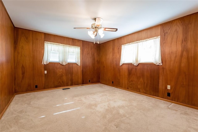 spare room with light carpet, plenty of natural light, and ceiling fan