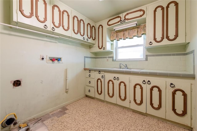 kitchen with tile counters, sink, and backsplash