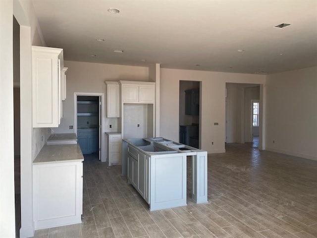 kitchen with light hardwood / wood-style flooring, white cabinets, and a kitchen island