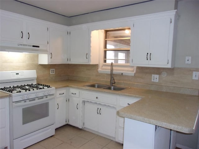 kitchen featuring white range with gas cooktop, sink, backsplash, and white cabinets