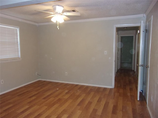 empty room with dark wood-type flooring, ceiling fan, ornamental molding, and a textured ceiling