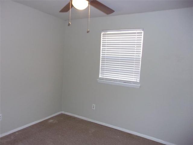 empty room featuring ceiling fan and carpet