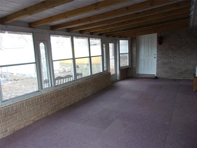 unfurnished sunroom featuring a wealth of natural light and beamed ceiling