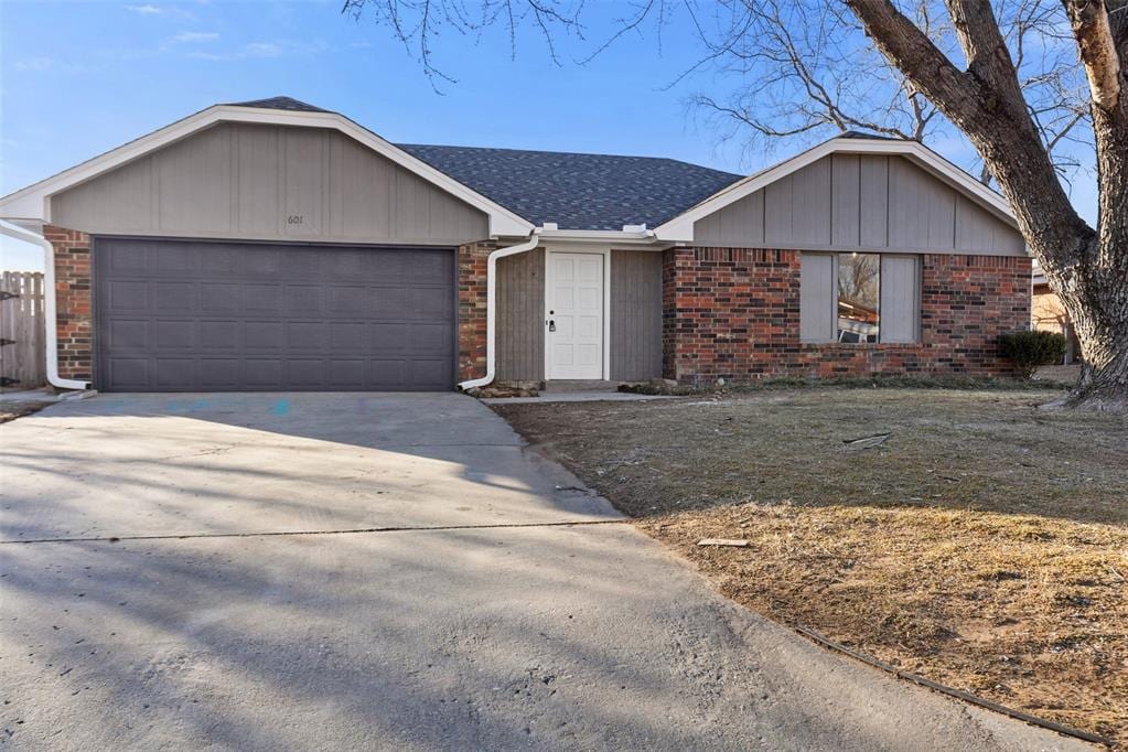 single story home featuring a garage and a front lawn