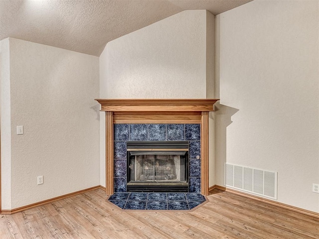 details featuring a textured ceiling, a fireplace, and wood-type flooring