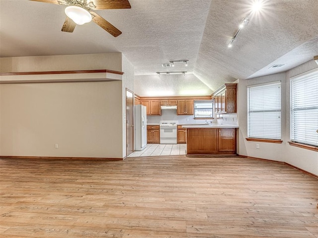 kitchen with white appliances, light hardwood / wood-style flooring, a textured ceiling, and vaulted ceiling