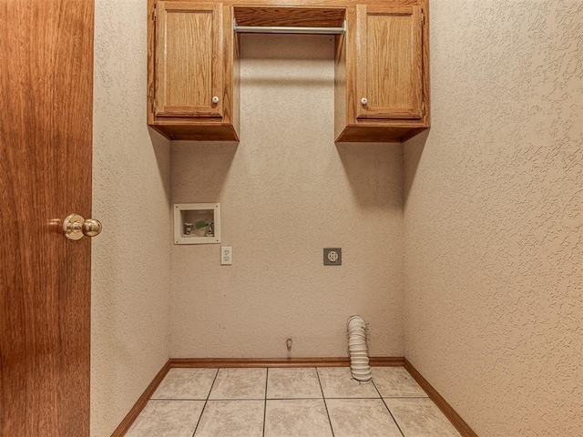 laundry area featuring cabinets, electric dryer hookup, washer hookup, and light tile patterned floors