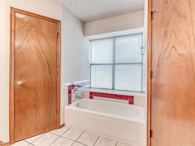 bathroom featuring a tub to relax in, tile patterned floors, and a textured ceiling