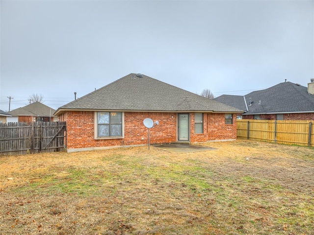 back of house with a yard and a patio