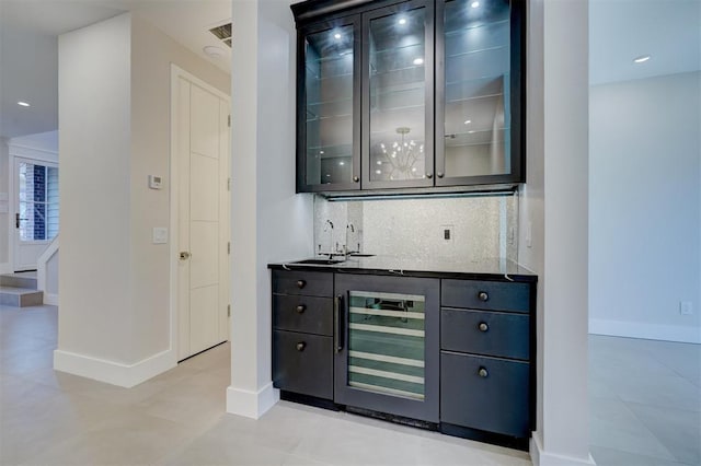 bar with backsplash, sink, and beverage cooler