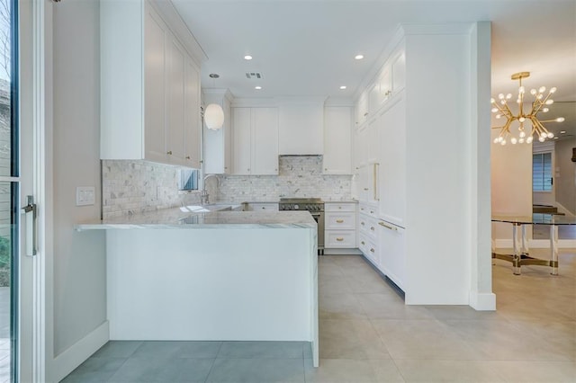 kitchen with hanging light fixtures, white cabinetry, backsplash, and kitchen peninsula