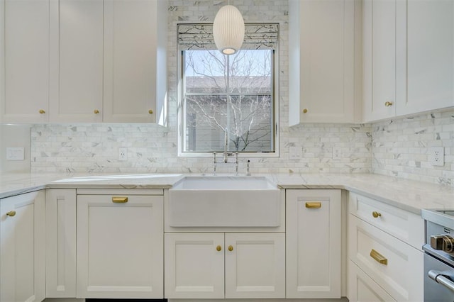 kitchen with light stone countertops, sink, white cabinets, and decorative backsplash