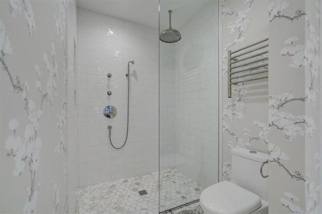 bathroom featuring tiled shower and toilet